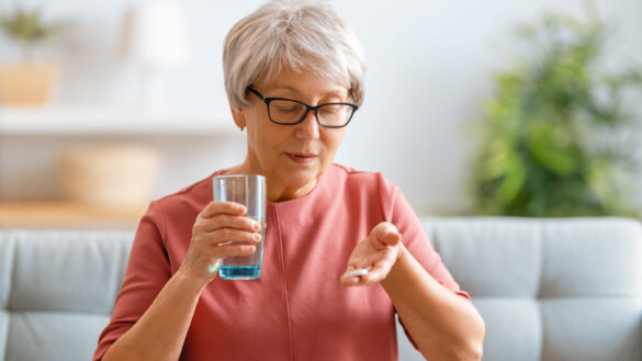 Senior,Woman,Holding,Pill,And,Glass,Of,Fresh,Water,,Taking